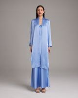 Model wearing a periwinkle silk Featherlight Wrap Blouse with long front sashes.