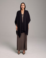 Model wearing a black alpaca duster over a brown dress