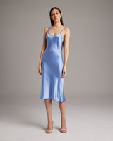 Model wearing a blue Midi Slip Dress, showcasing its elegant drape and style.