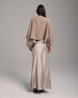 Model wearing a taupe alpaca crop top with a satin skirt from the back