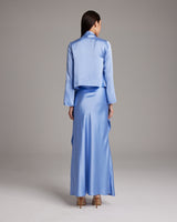 Model wearing a blue silk Featherlight Wrap Blouse from the back