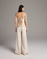 Model wearing a liquid silk tank top with spaghetti straps and palazzo pants, viewed from the back.