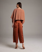 Model wearing a shimmering copper bolero with matching rust pants, viewed from the back.