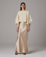 Model wearing an ivory alpaca crop top with a satin skirt