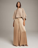Model wearing a beige alpaca crop top with beige palazzo pants