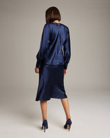 Model wearing a navy Boatneck Blouse in Silk Charmeuse, back view