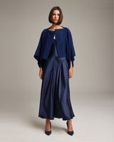 Model wearing a navy bolero over a satin dress