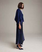 Model wearing a navy bolero over a satin skirt