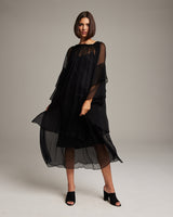 Model wearing a black Cascade Dress with layered chiffon sleeves