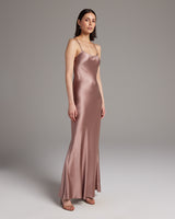 Model wearing a rose-colored liquid silk slipdress, showcasing its elegant design.