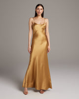 Model wearing a gold Liquid Silk Slipdress, showcasing its elegant design.