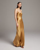 Model wearing a gold Liquid Silk Slipdress, showcasing its elegant drape and design.