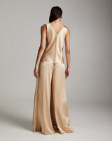 Model wearing a blush silk palazzo pants and tank top from the back