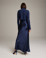 Model wearing a navy Manos Cropped Sweater over a satin slip dress, viewed from the back.