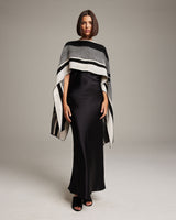 Model wearing a black and ivory poncho with geometric patterns