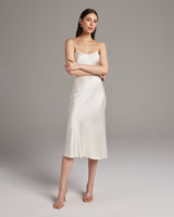 Model wearing a cream Midi Slip Dress with spaghetti straps