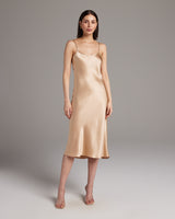 Model wearing a blush satin Midi Slip Dress with spaghetti straps