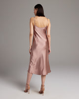 Back view of a model wearing a blush Midi Slip Dress with spaghetti straps.