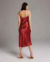 Back view of a model wearing a red satin midi slip dress