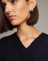 Model wearing Millapani Lukutuwe Sapphire Stud Earrings, showcasing blue sapphires and 18k white gold.