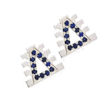 Oversized stud earrings featuring the Lukutuwe symbol, set with blue sapphires in 18k white gold.