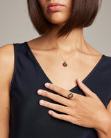 Model wearing Millapani Cuarzo Ring and necklace, showcasing jewelry on a hand and neck.