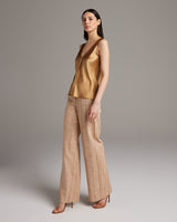 Model wearing a gold silk raw edge tank top with palazzo pants