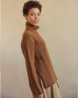 Model wearing a caramel oversized ribbed knit sweater with a turtleneck