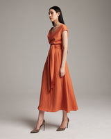 Model wearing a persimmon Linen Bralette Wrap Top with a tied sash