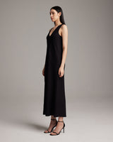 Model wearing a black linen V neck maxi dress, side view