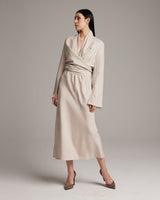 Model wearing a beige Linen Featherlight Wrap Blouse with long sleeves and a wrap design.