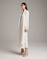 Model wearing a white Linen Featherlight Wrap Blouse, showcasing its drapey fabric and long front sashes.