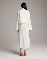 Model wearing a white Linen Featherlight Wrap Blouse from the back