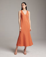Model wearing a linen V neck dress in persimmon color