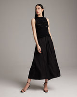 Model wearing a black Longer Flammé Knit Crop Top with a long black skirt