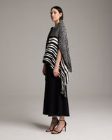 Model wearing a black and white striped Petite Cascade Wrap, standing in profile.