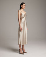 Side view of a beige V-neck slip dress with spaghetti straps