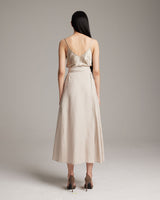 Model wearing a back view of a beige Butterfly Wrap Skirt