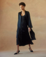 Model wearing a black Silk Featherlight Wrap Blouse with flowing sleeves