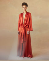 Model wearing a rust-colored Silk Featherlight Wrap Blouse with a tied front sash