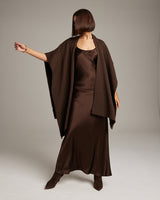 Model wearing a brown alpaca duster over a brown satin dress