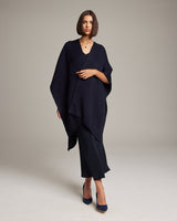 Model wearing a navy solid alpaca duster with a v-neck and black pants
