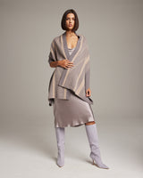 Model wearing a taupe and beige striped zig zag shawl over a satin dress