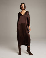 Model wearing a brown silk tunic dress with a deep V-neck and loose fit