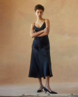 Model wearing a black V-neck slip dress with spaghetti straps