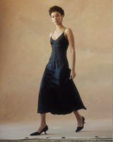 Model wearing a black V-neck slip dress with spaghetti straps
