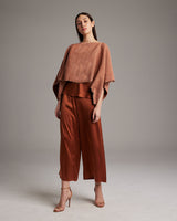 Model wearing a shimmering copper crop top and matching pants