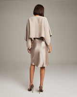 Model wearing a textured cotton bolero over a satin skirt, viewed from the back.