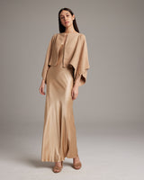Model wearing a camel bolero over a satin slip dress