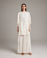 Model wearing a textured cotton fringe kaftan with a belt, showcasing its elegant flow and fringe detail.